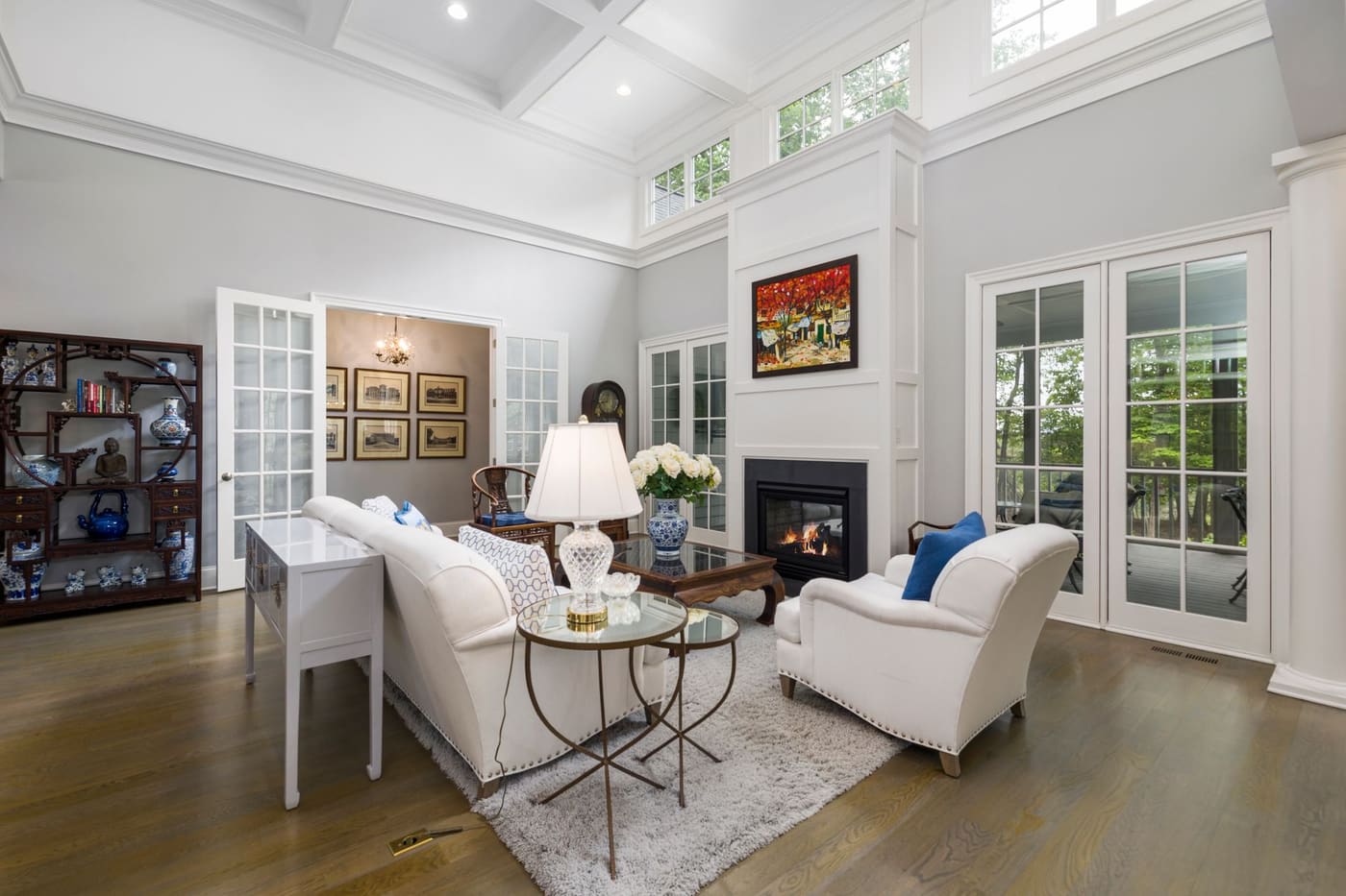 Living room with a white sofa and armchairs grouped on a rug in front of a fireplace
