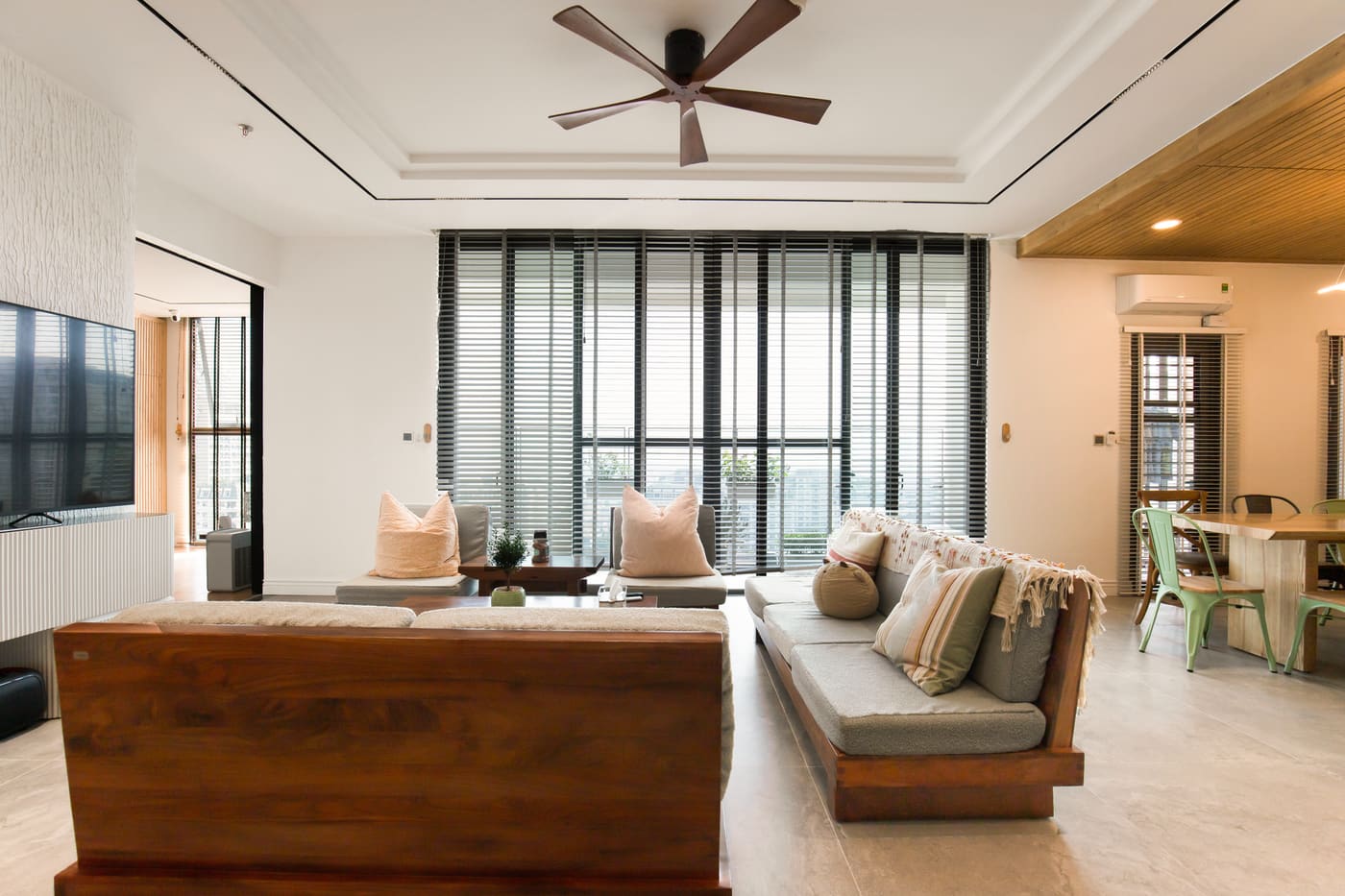 Large living room with a wooden coffee table, a sofa and big windows