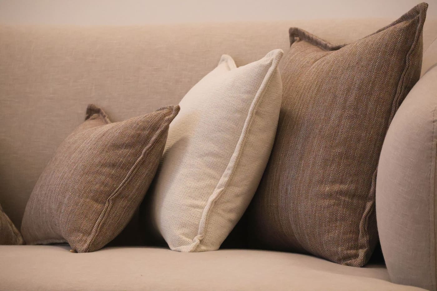 Beige sofa with brown and cream cushions